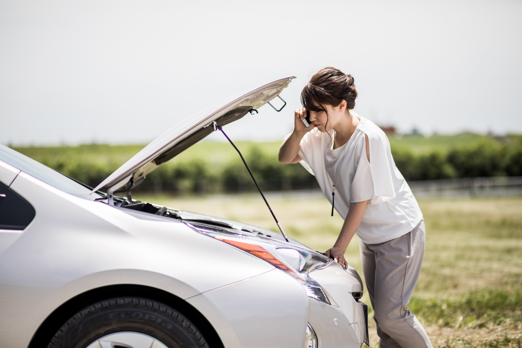 Woman on side of road with car